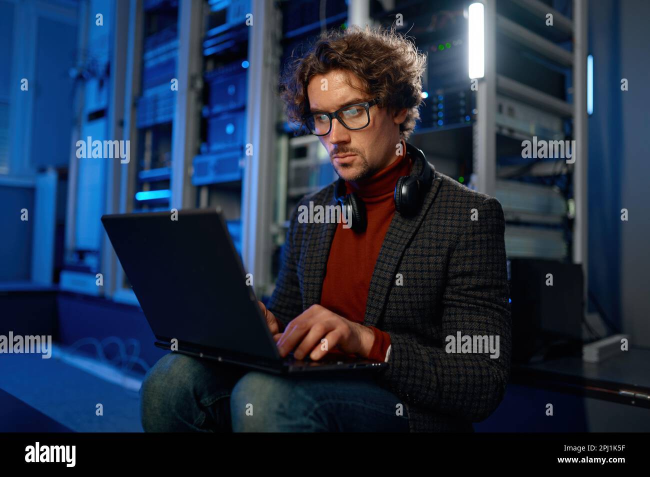 Network engineer using digital tablet in server room during maintenance work Stock Photo