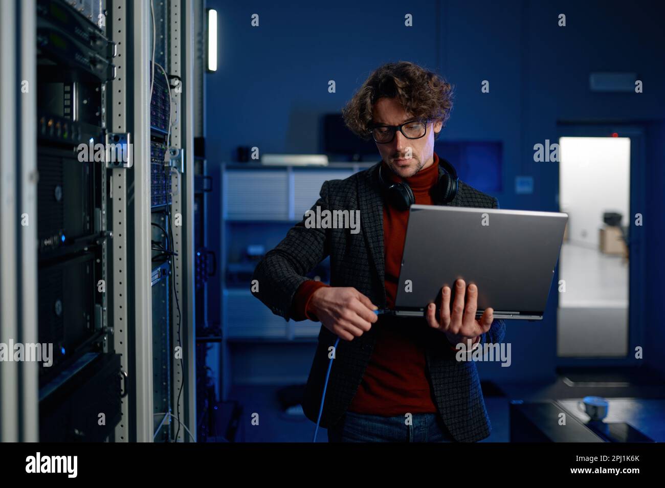 IT technician switching wire to laptop computer Stock Photo