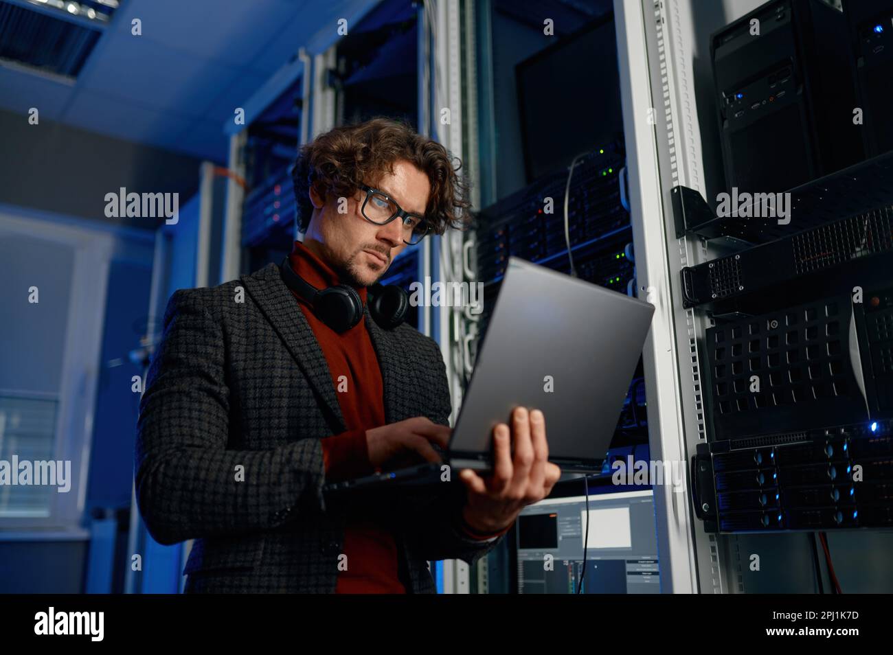 IT technician using digital tablet while working in data center with server rack Stock Photo