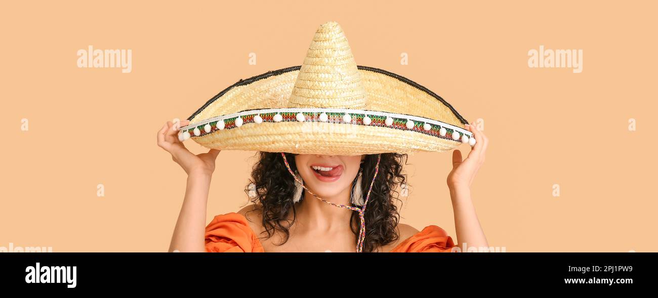 Beautiful Mexican woman in sombrero hat on beige background Stock Photo