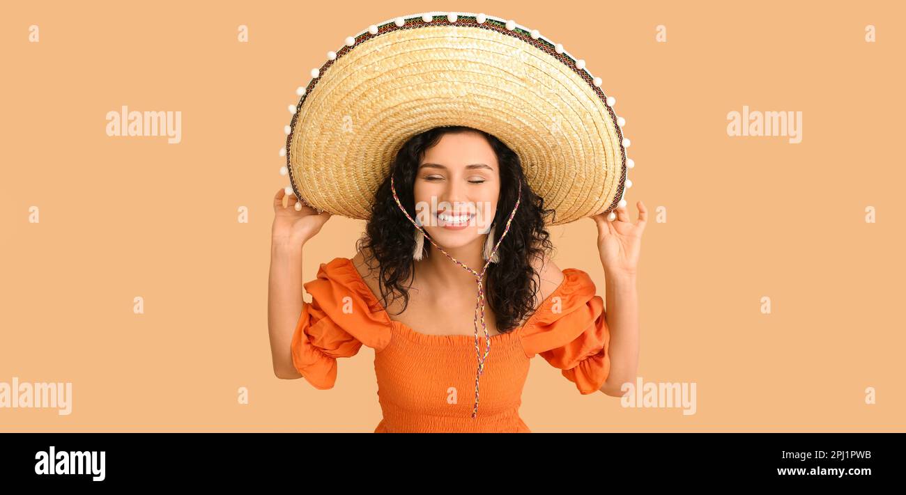 Beautiful Mexican woman in sombrero hat on beige background Stock Photo