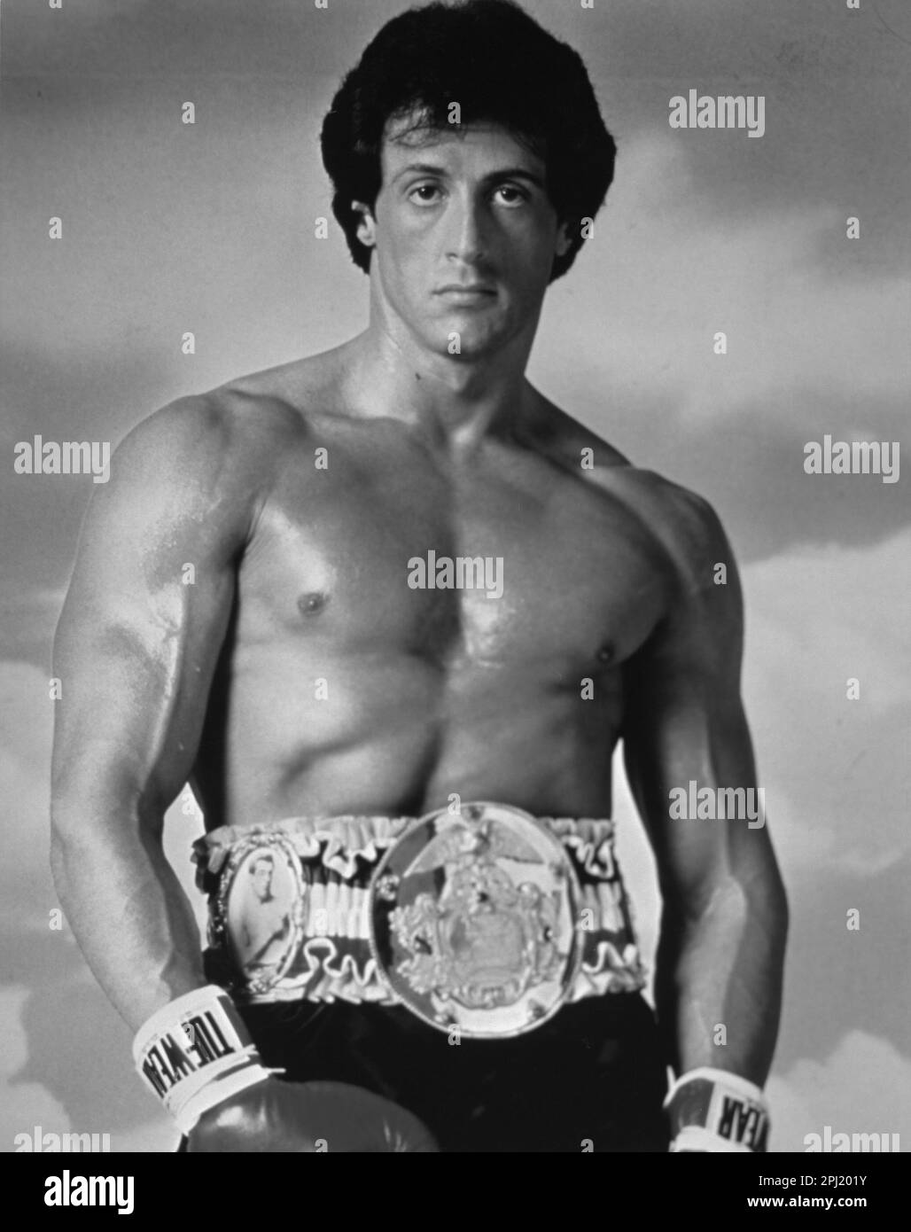 PR shot of Sylvester Stallone in boxing shorts with championship winning belt from movie franchise,  Rocky Stock Photo