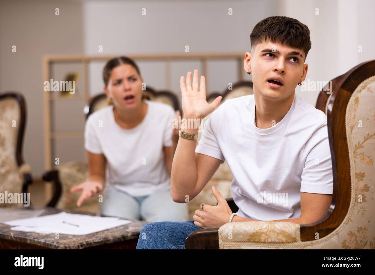 Portrait of upset man sitting while quarrel with wife at home Stock Photo