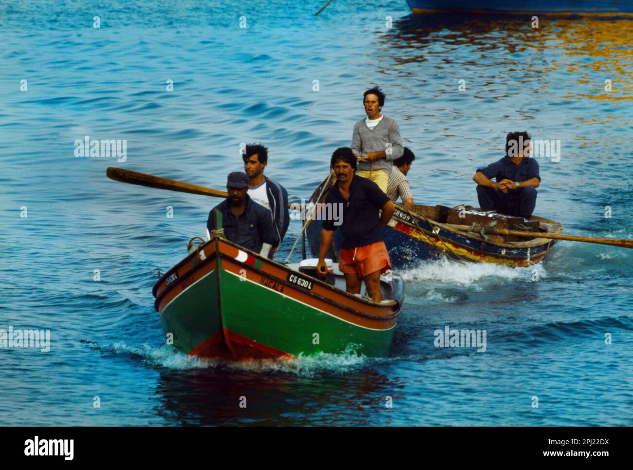 Cascais Portugal Sardine Fishermen with Motorboat Towing Men on Rowing Boat Stock Photo