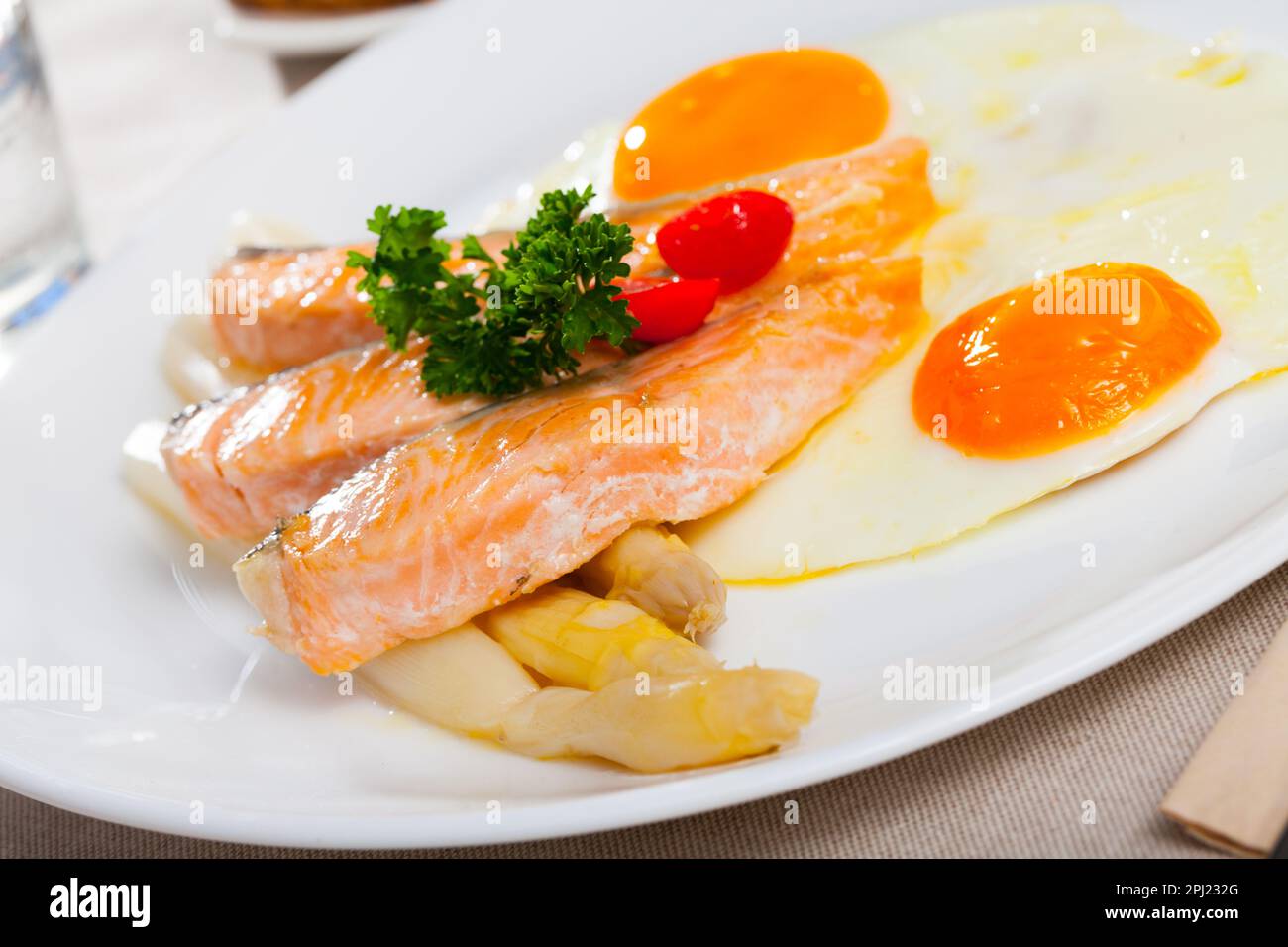 Fried salmon with scrambled eggs and asparagus Stock Photo
