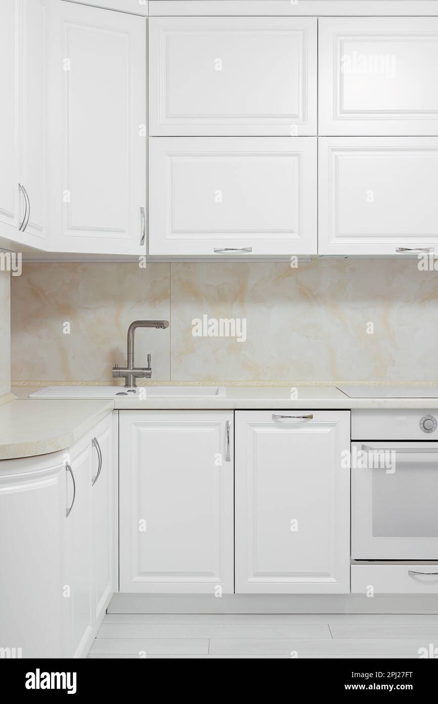 Facade of white kitchen furniture in the kitchen interior Stock Photo