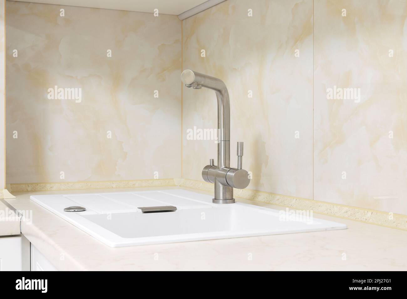 Faucet with white granite sink in the kitchen Stock Photo Alamy