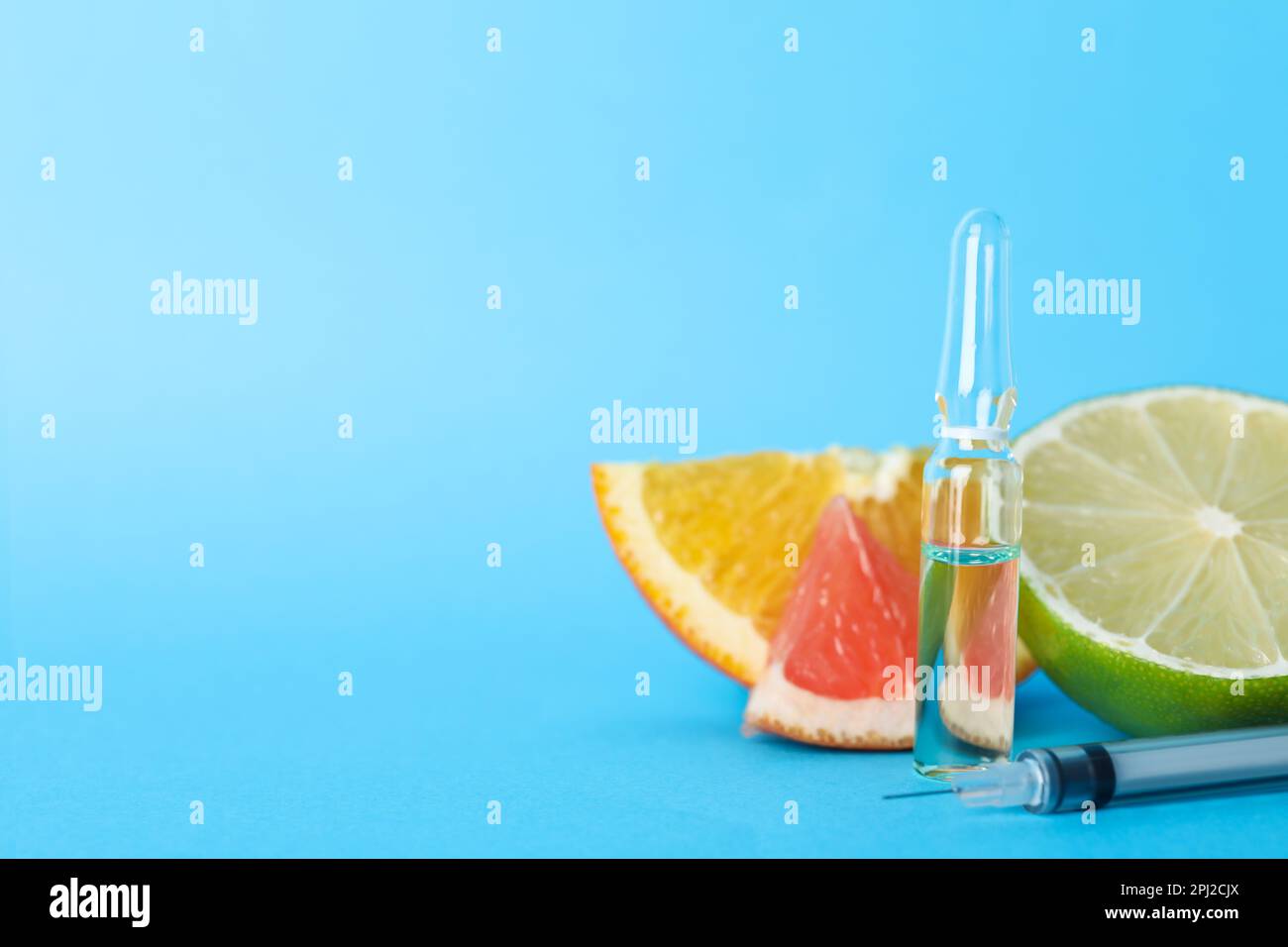 Pharmaceutical ampoule with medication, syringe and citrus fruits on