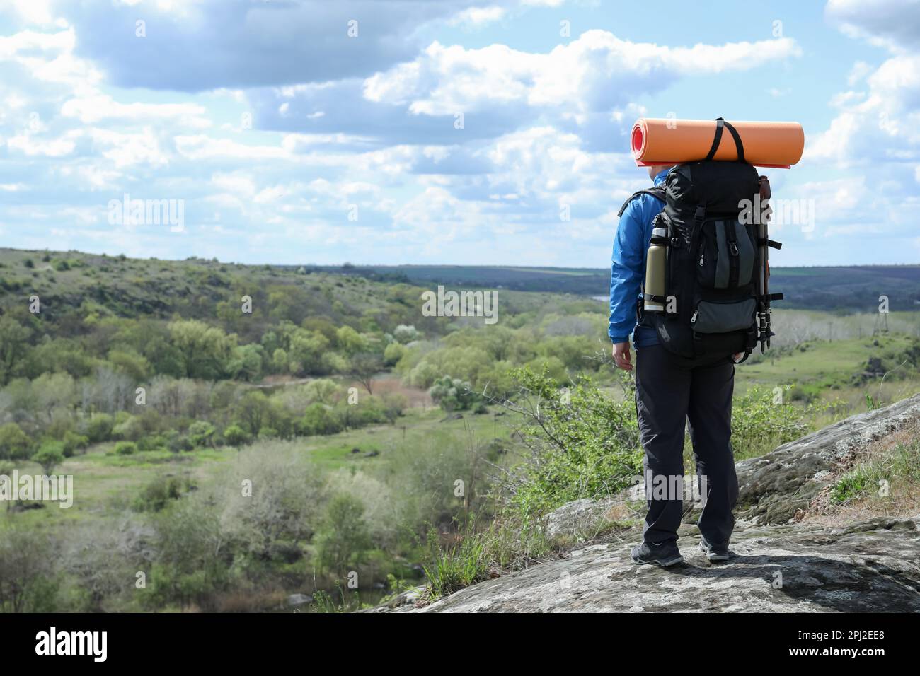 Hiker with backpack ready for journey on rocky hill, back view Stock ...