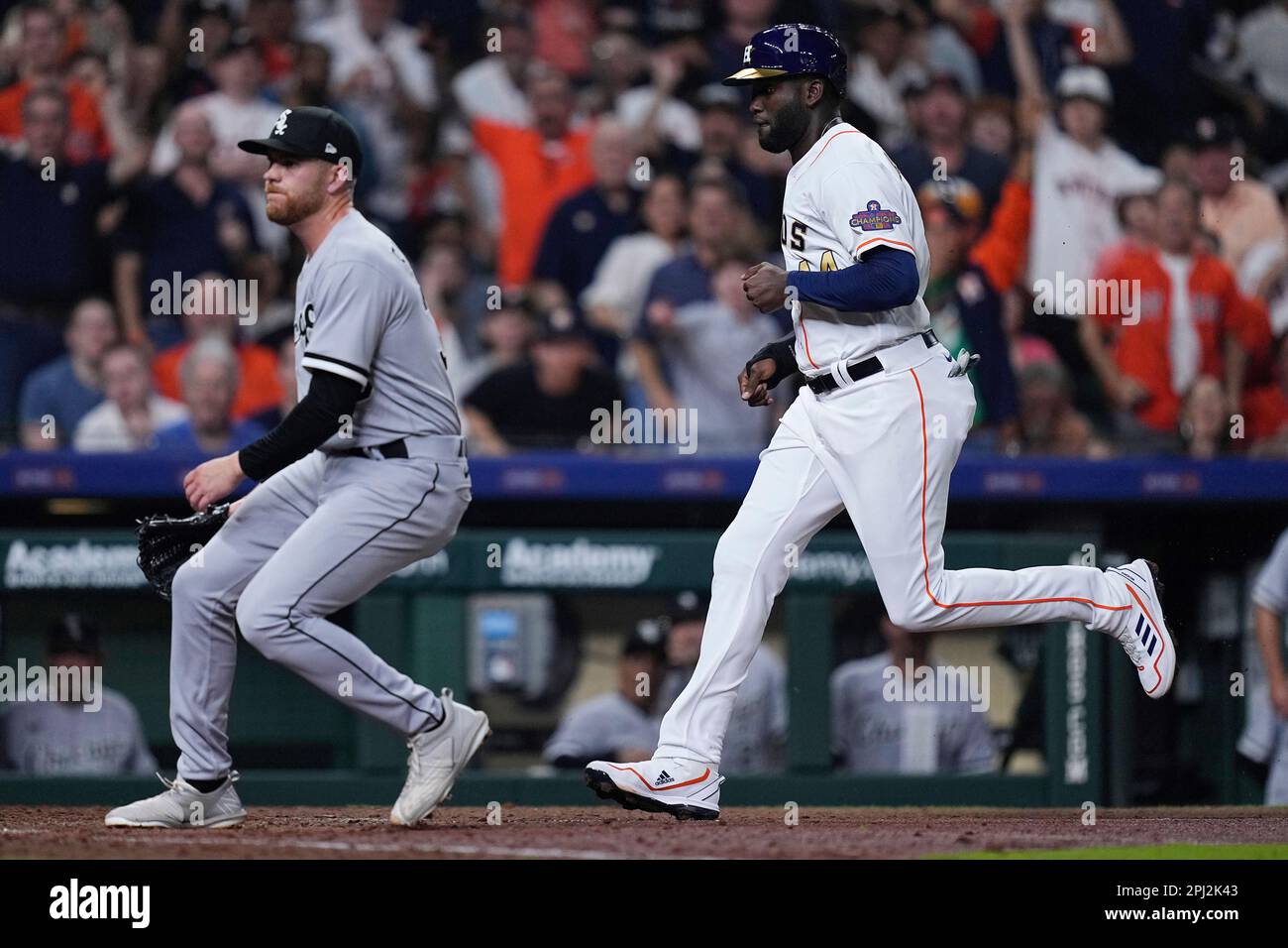 Houston Astros' Yordan Alvarez, right, scores on a wild pitch by