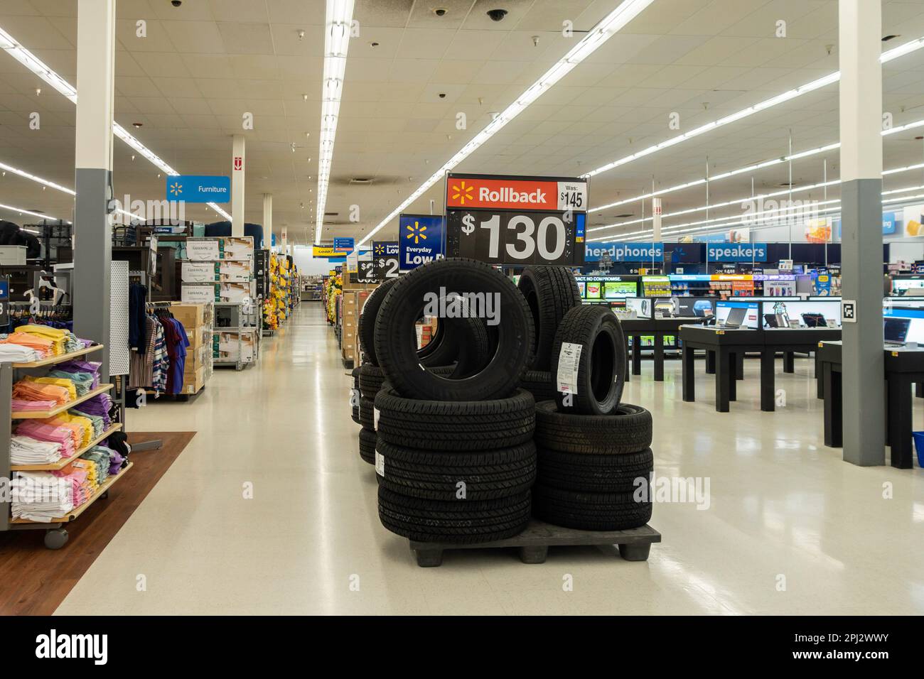 A stack of new tires in a Walmart aisle with a rollback price sign. Interior, Wichita, Kansas, USA. Stock Photo