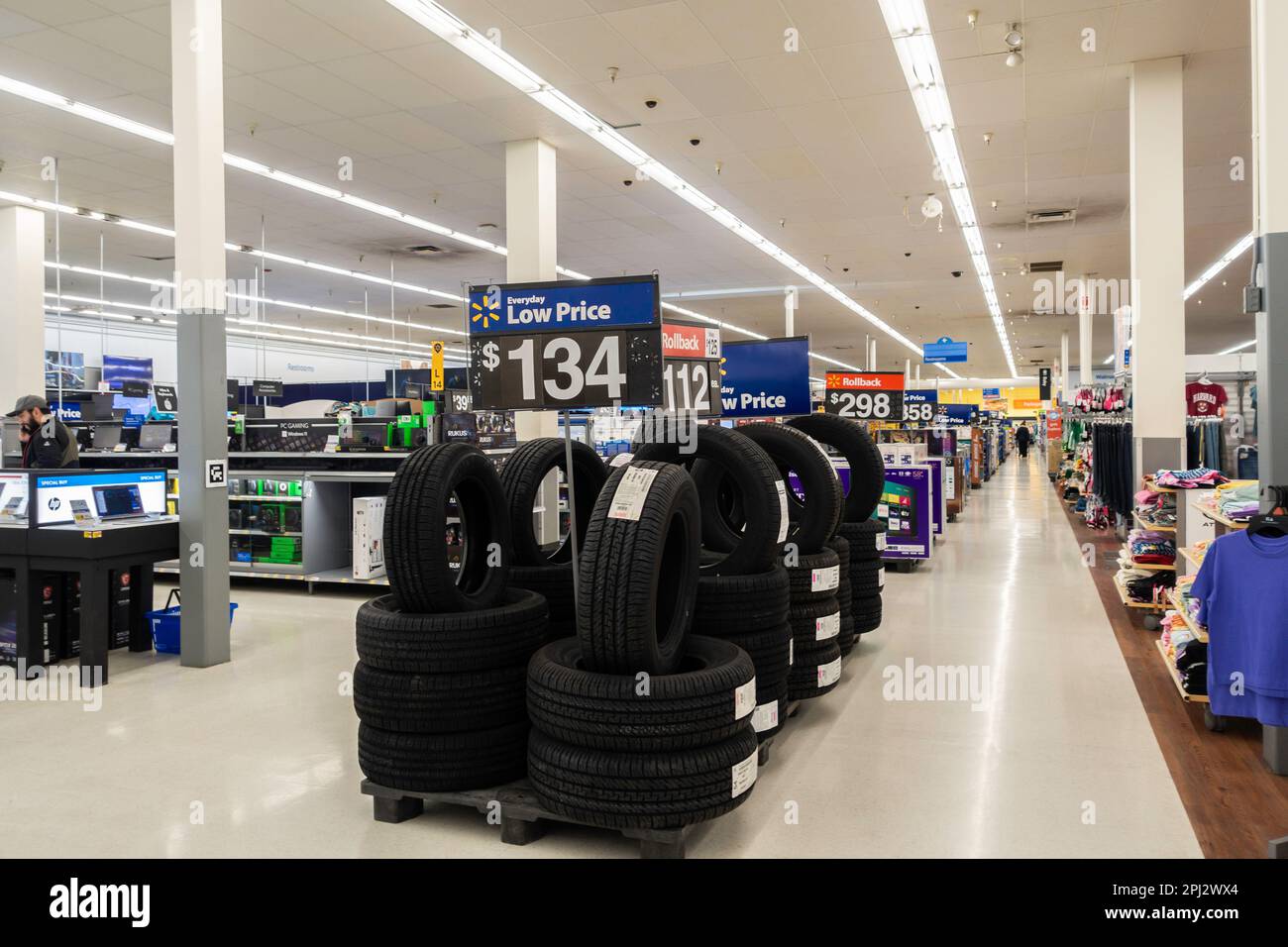 A stack of new tires in a Walmart aisle with a low price sign. Interior, Wichita, Kansas, USA. Stock Photo