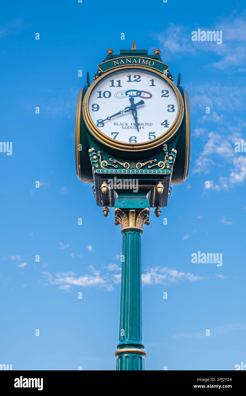Street clock, clock on a pole at the blue sky background. Vintage street clock on a wooden pole in Nanaimo BC Canada-October 5,2023. Street photo, nob Stock Photo
