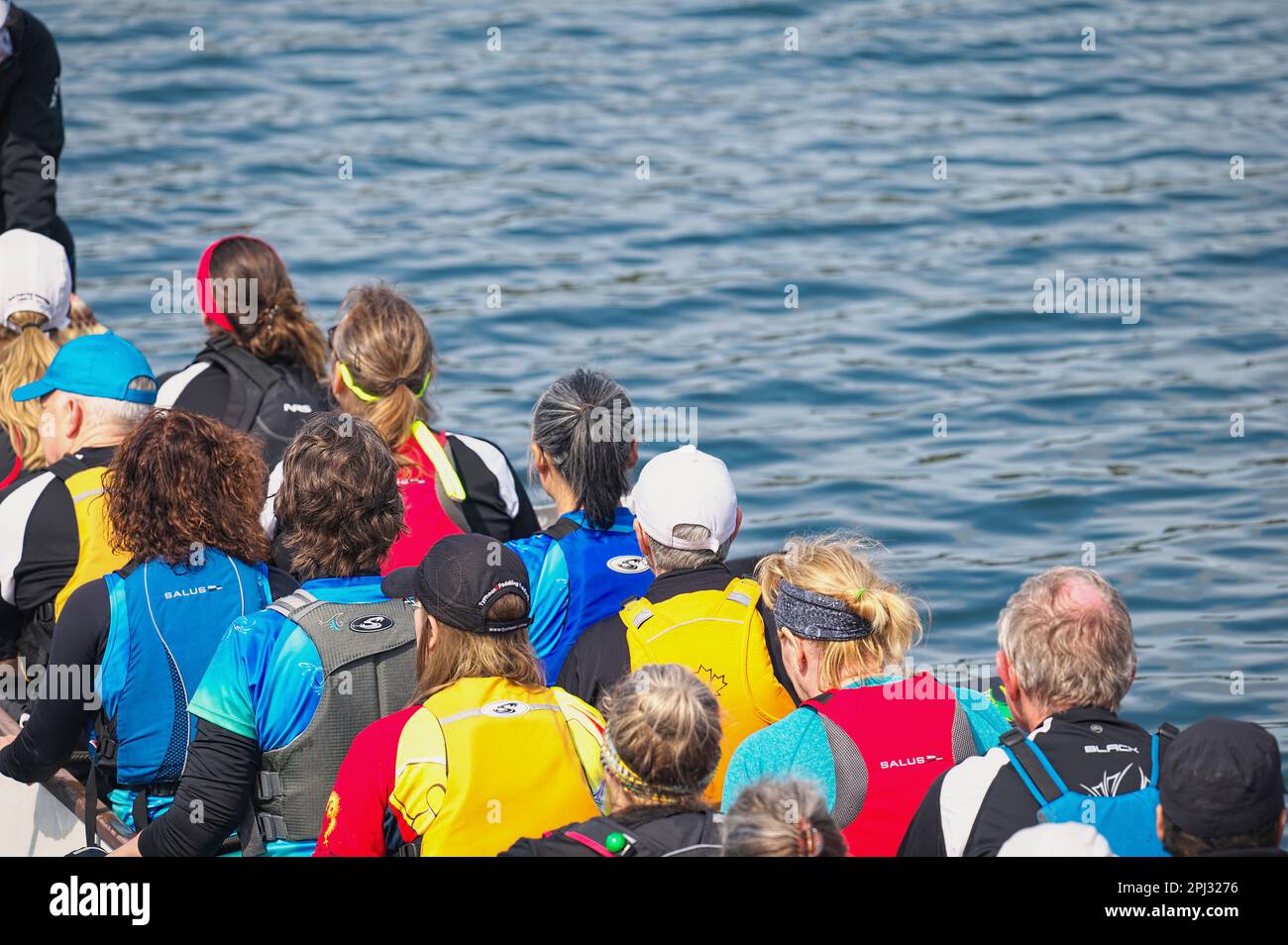 Dragon Boat Race - competitors sitting in a boat facing away from camera - Inlet Spring Regatta 2022, Rocky Point Park, Port Moody, B. C., Canada. Stock Photo