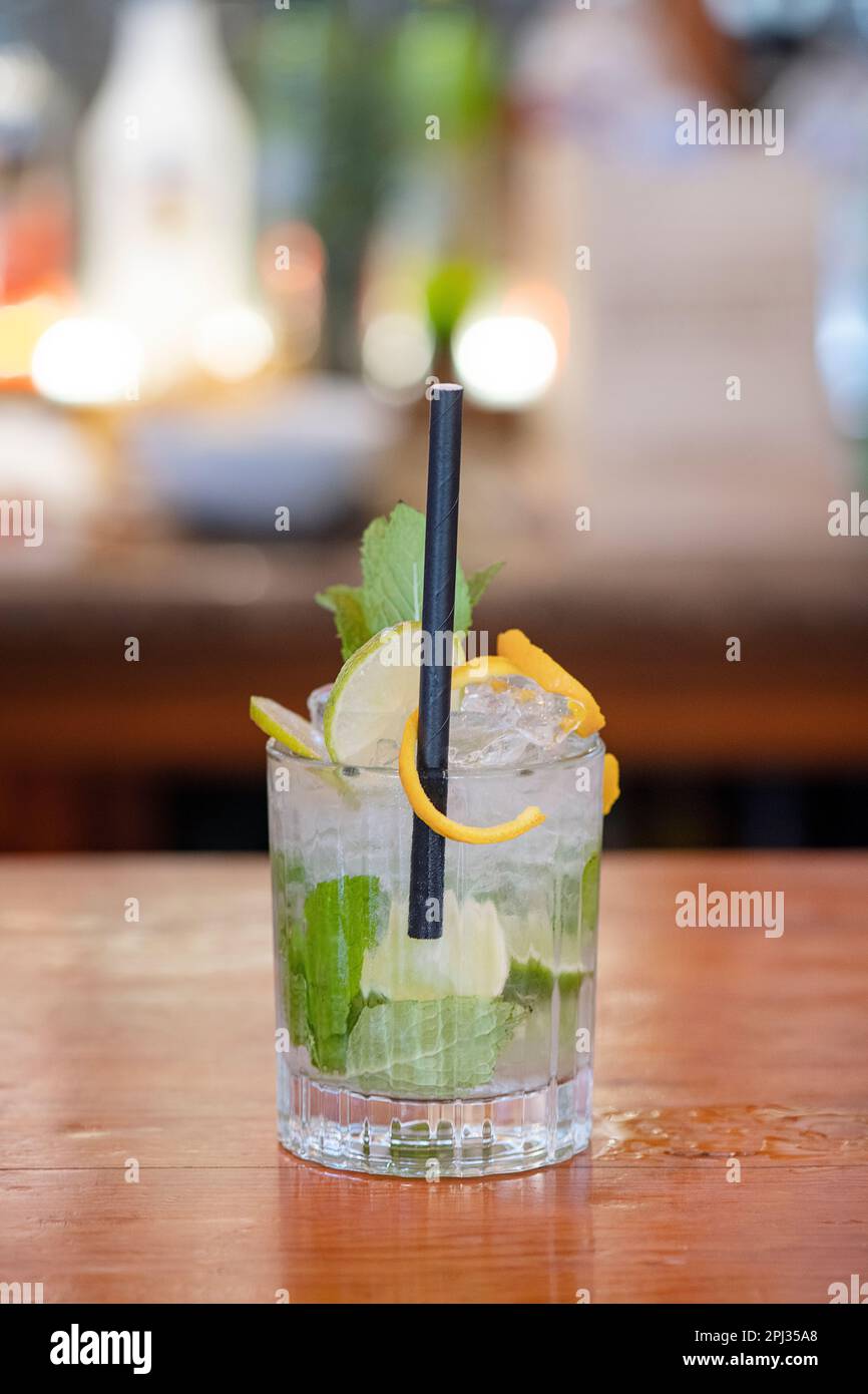 Mojito cocktail set on a bar table, refreshing alcoholic beverage originated in Cuba, typically made with rum, lime, mint, and sugarcane Stock Photo