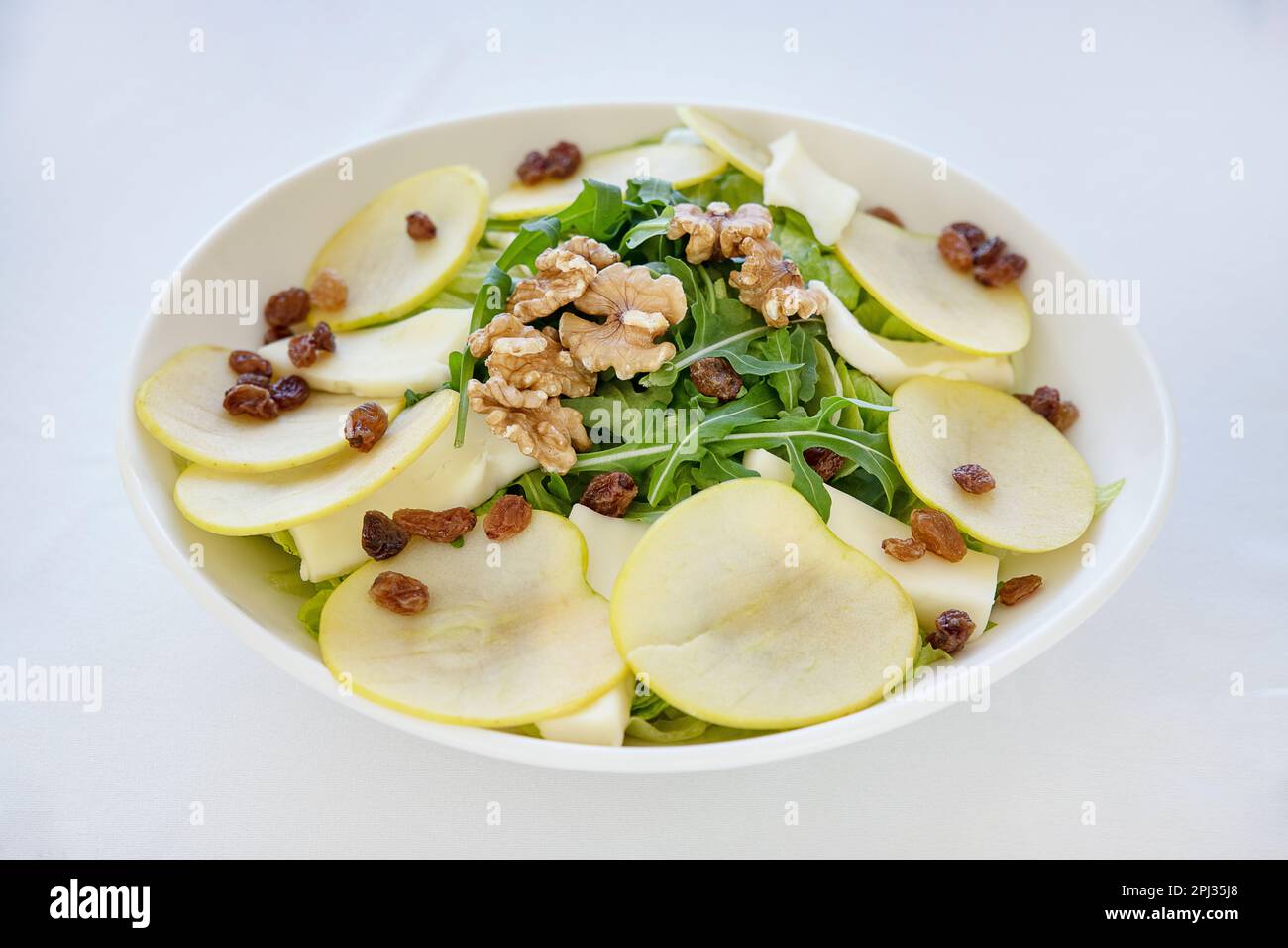Delicious fresh salad combining flavors and textures with crisp juicy apples for a hint of tanginess, earthy walnuts for a crunch and rocket leaves Stock Photo