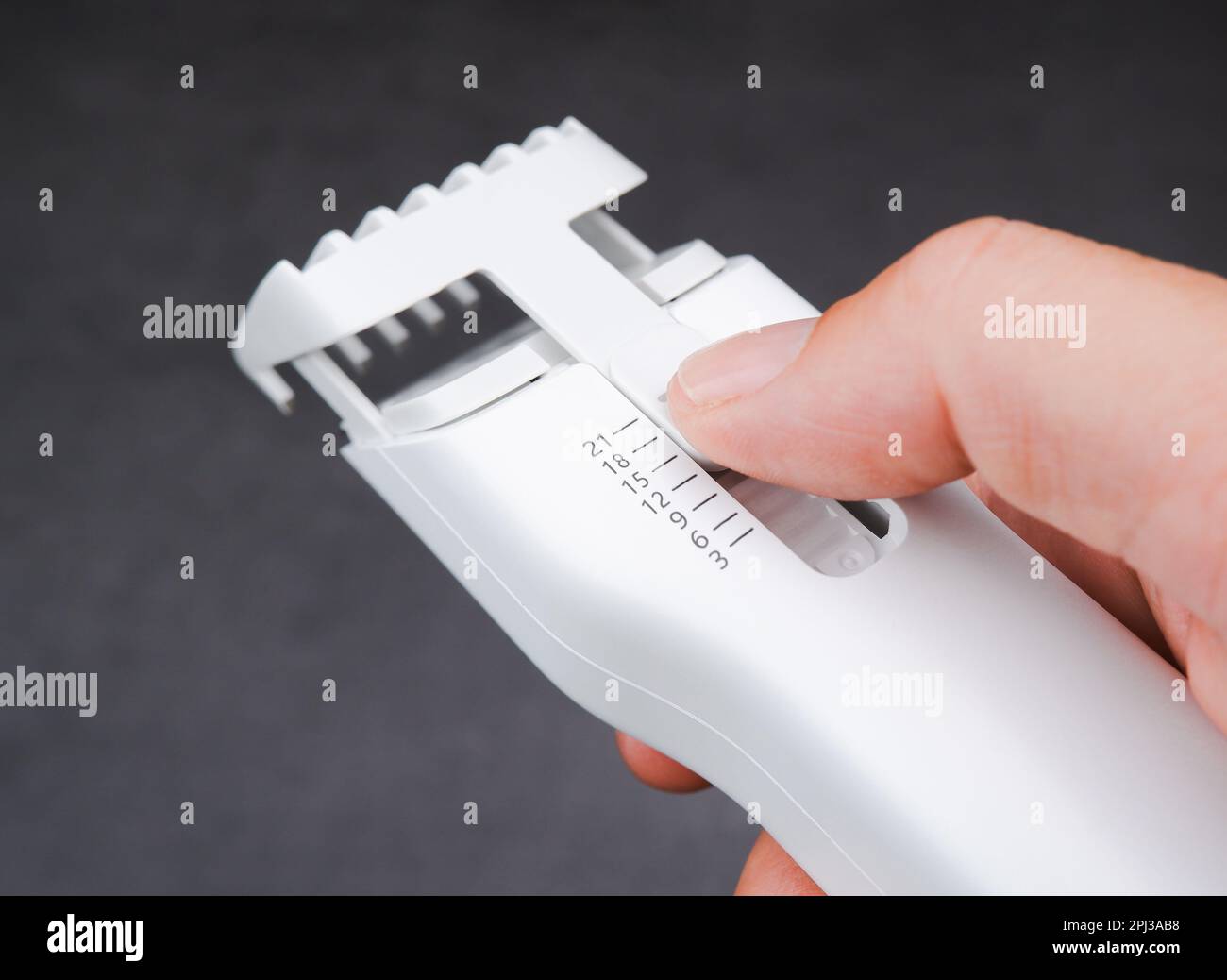 Closeup macro of hair clipper guide comb with manual knob in millimeter