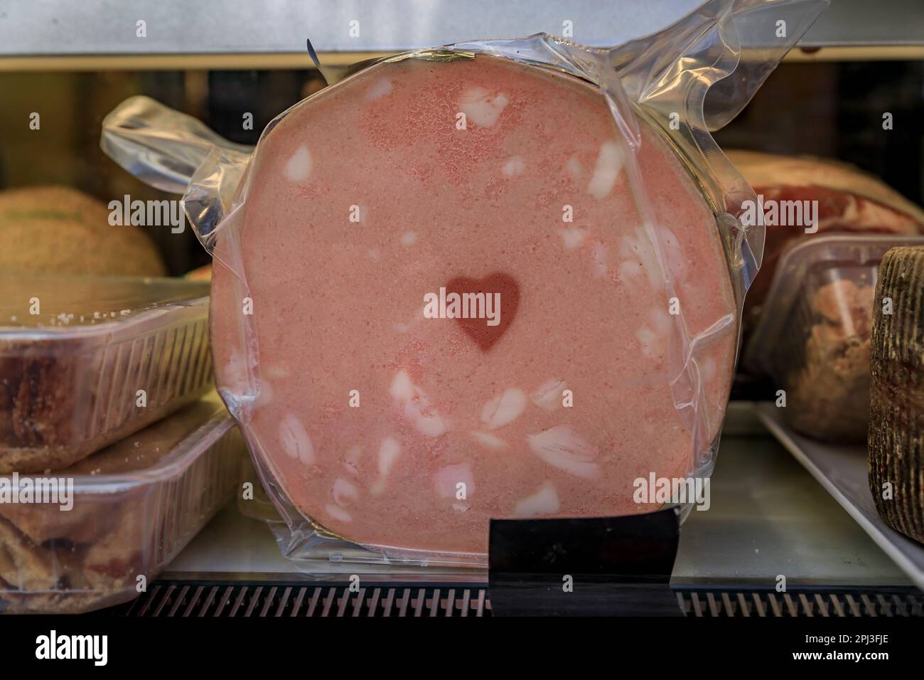 Loaf of mortadella with a heart design at a local butcher shop in the