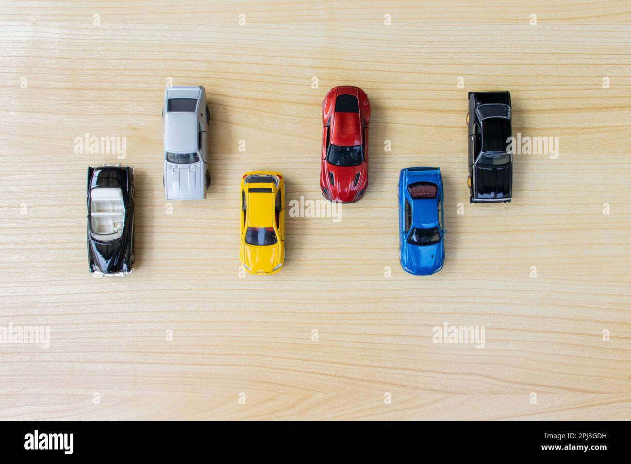 Group of toy cars isolated on wooden background, after some edits. Stock Photo