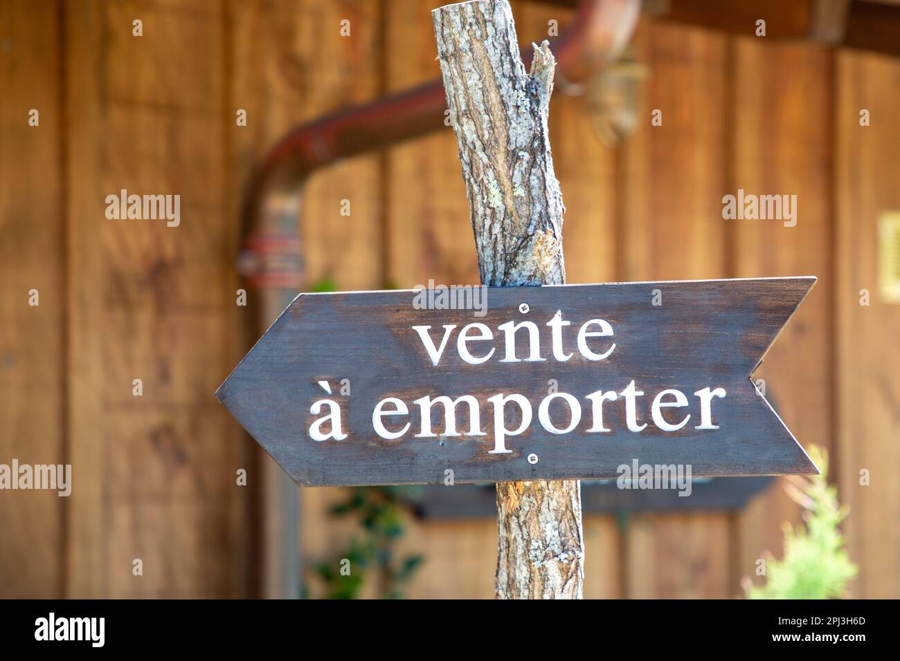 vente a emporter sign text means takeaway in wooden arrow outdoor fastfood restaurant Stock Photo