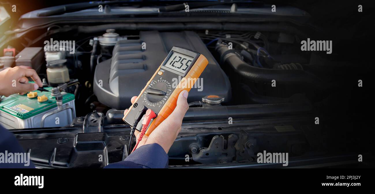 Technician checking car battery voltage Stock Photo Alamy