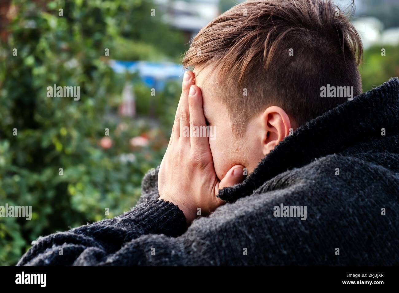 Sad Young Man close his Face oudoor Stock Photo - Alamy