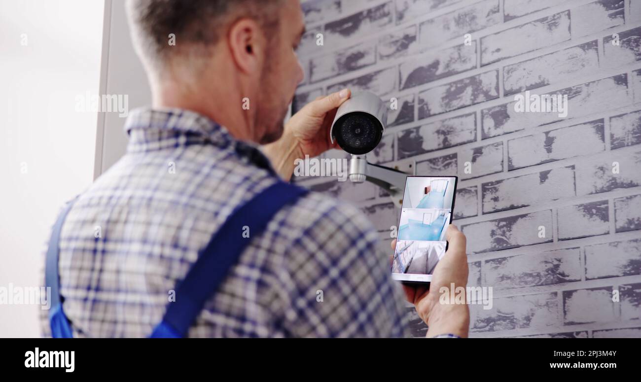 Technician Adjusting CCTV Camera For Video Surveillance Stock Photo