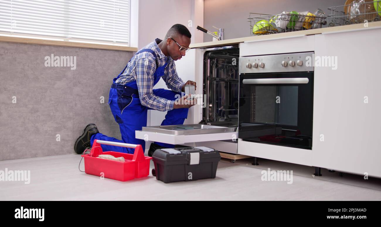 African American Repairman Fixing Dishwasher Appliance Machine Stock