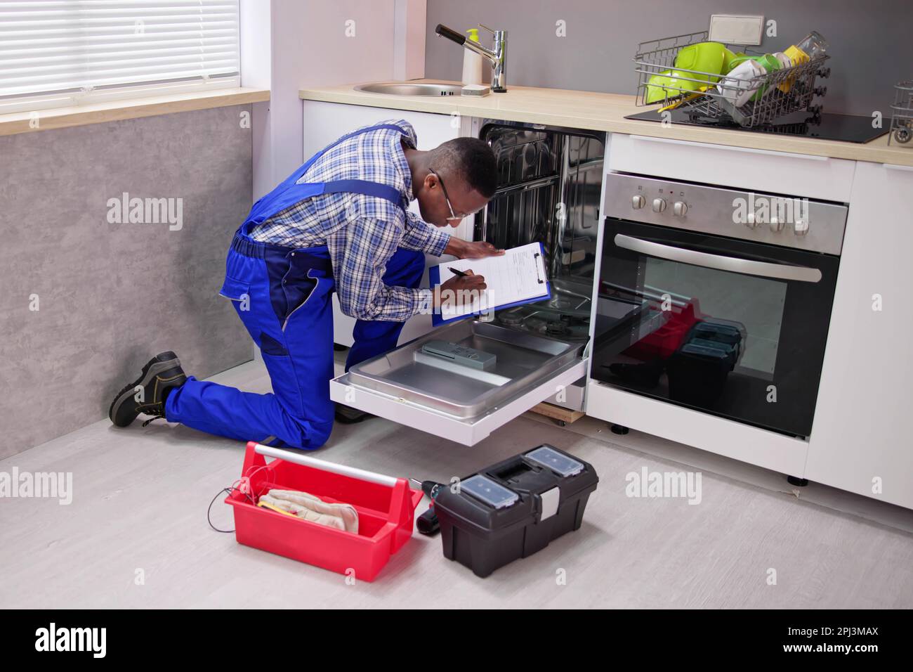African American Repairman Fixing Dishwasher Appliance Machine Stock