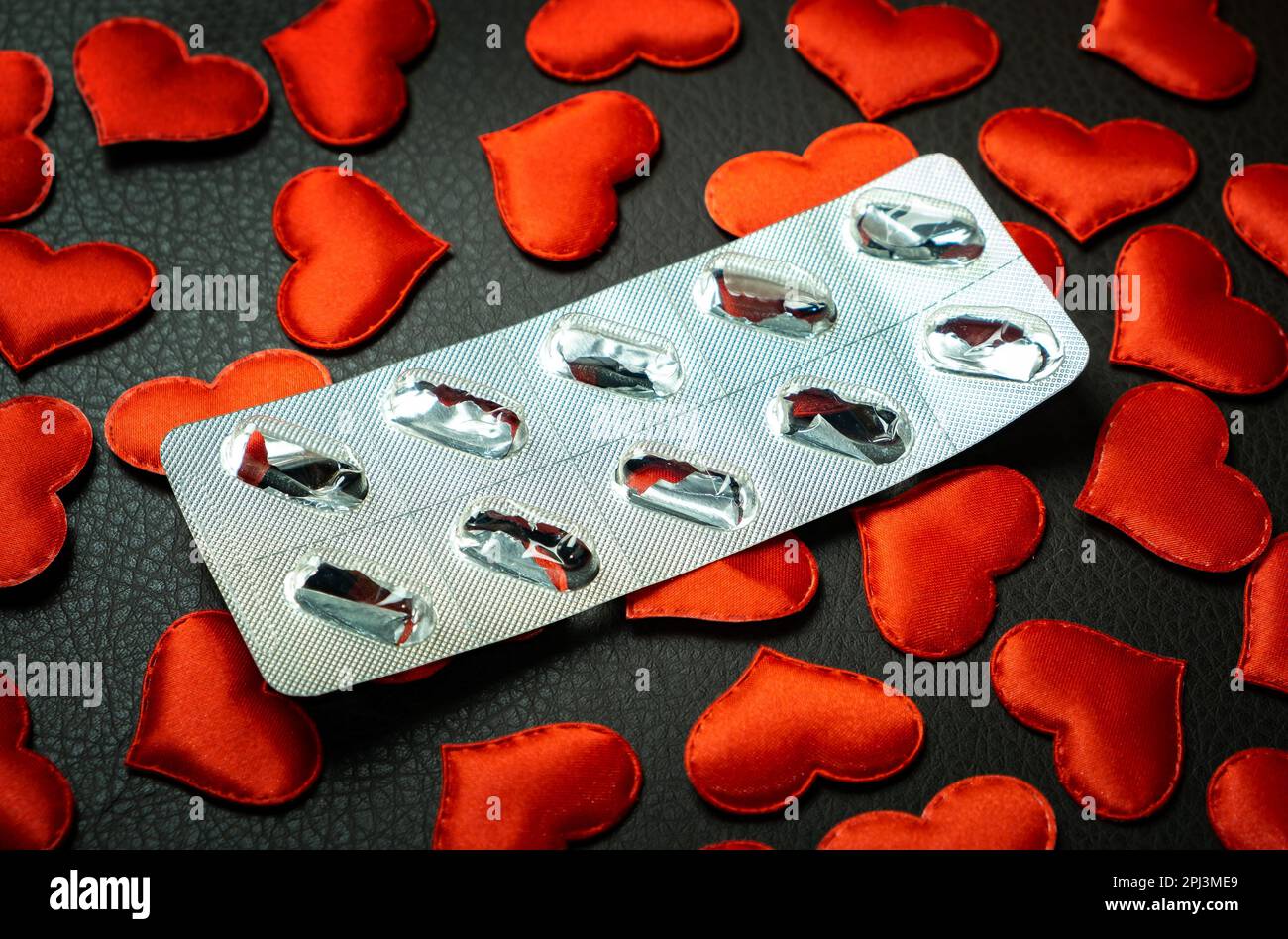 Empty Pack of the Pills on the Scattered Red Hearts Background closeup Stock Photo