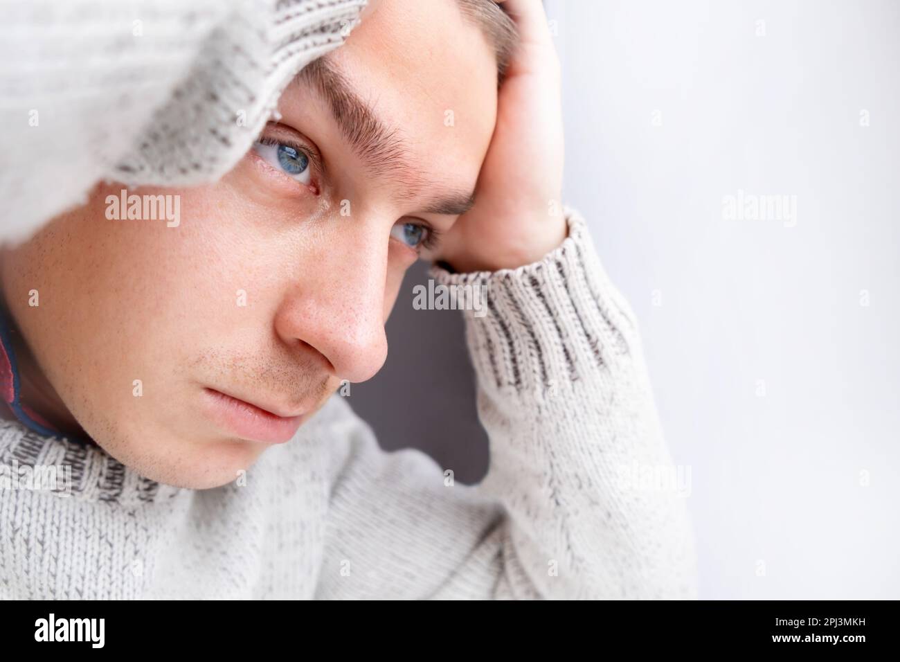 Sad Young Man Portrait at the Home by the Wall closeup Stock Photo