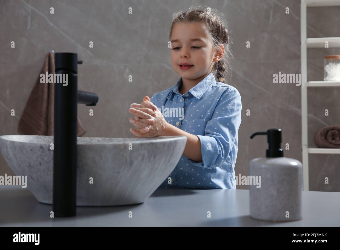Cute little girl washing hands with liquid soap in bathroom Stock Photo ...