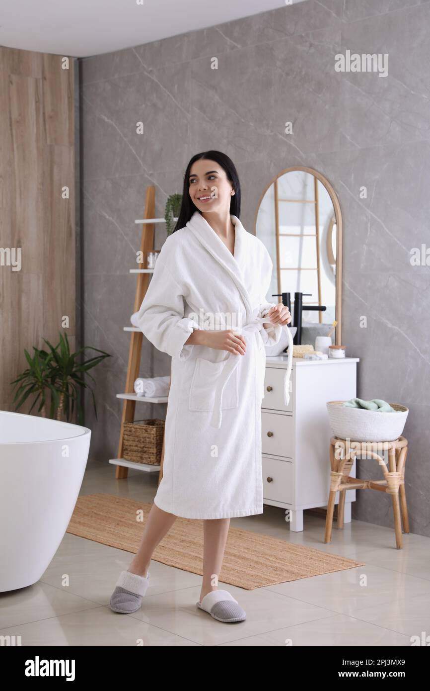 Beautiful young woman wearing soft white robe in bathroom Stock Photo Alamy