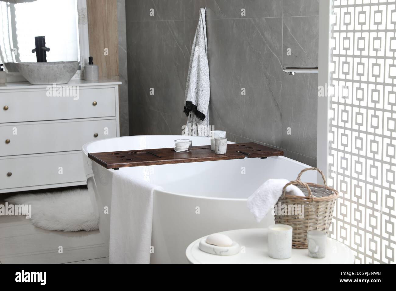 Modern white tub and table with toiletries in bathroom. Interior design ...