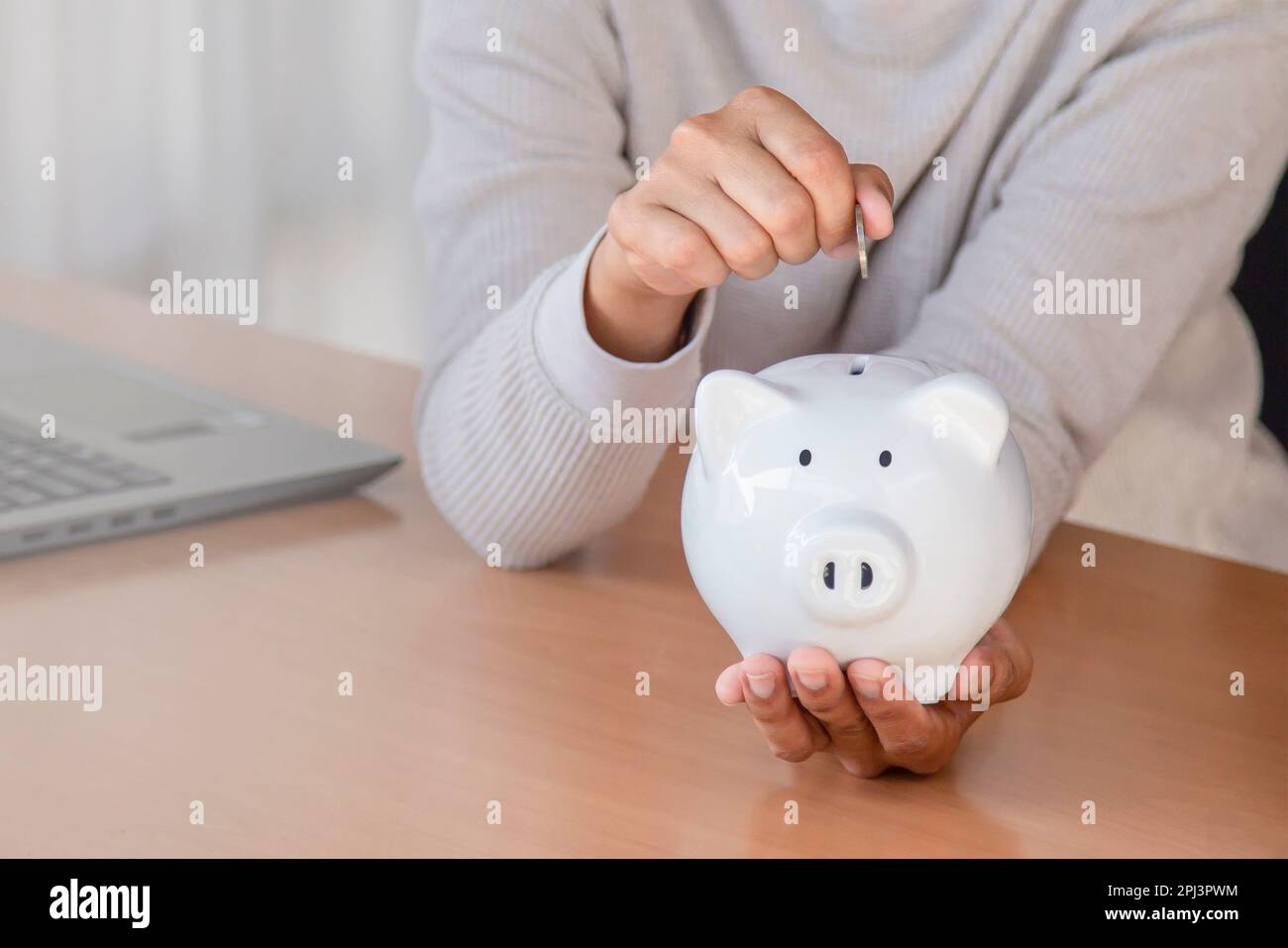 woman hand putting money coin into piggy for saving money wealth and ...