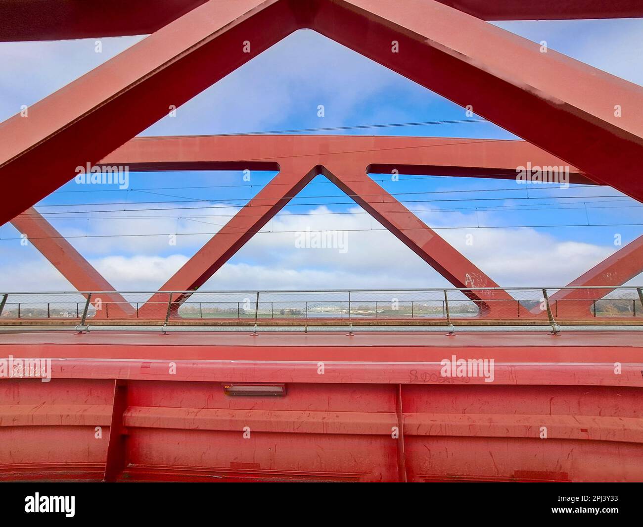 Red steel bridge called Hanzeboog over the river IJssel between Hattem