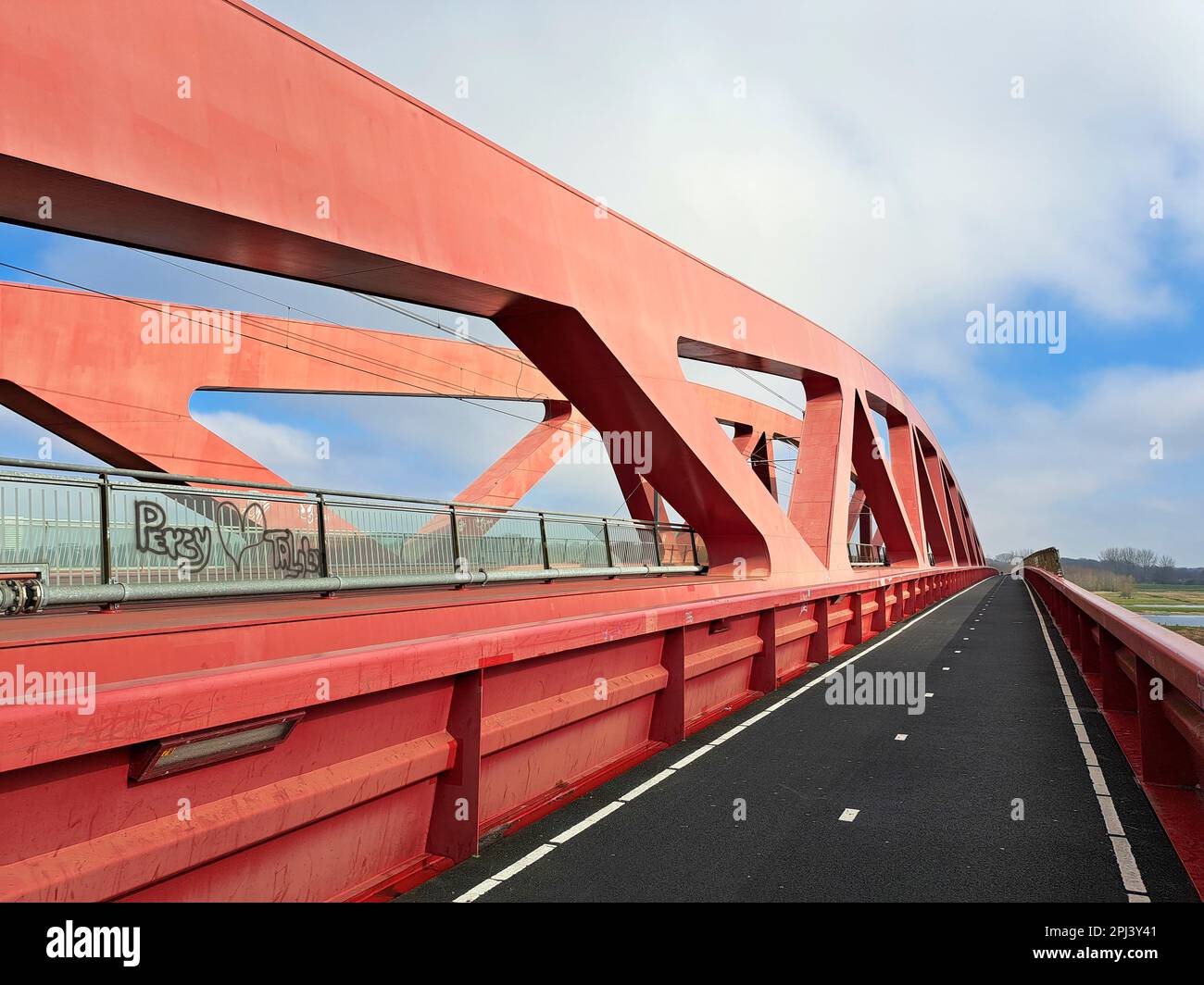 Red steel bridge called Hanzeboog over the river IJssel between Hattem