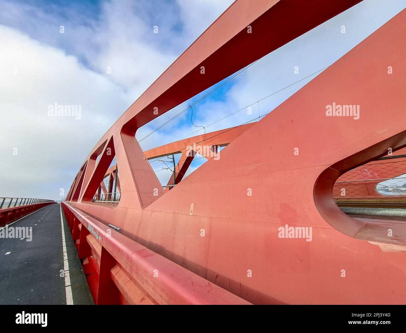 Red steel bridge called Hanzeboog over the river IJssel between Hattem