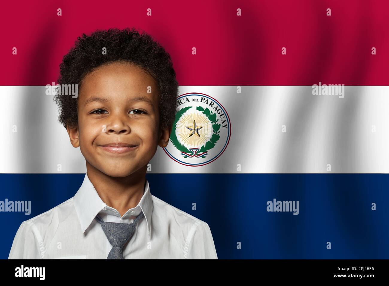 Paraguayan kid boy on flag of Paraguay background. Education and childhood concept Stock Photo