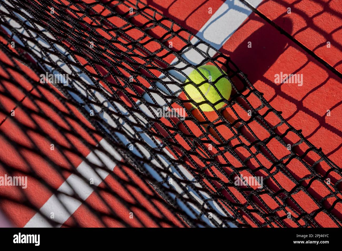 selective focus, a ball in the net of a tennis court painted red Stock Photo