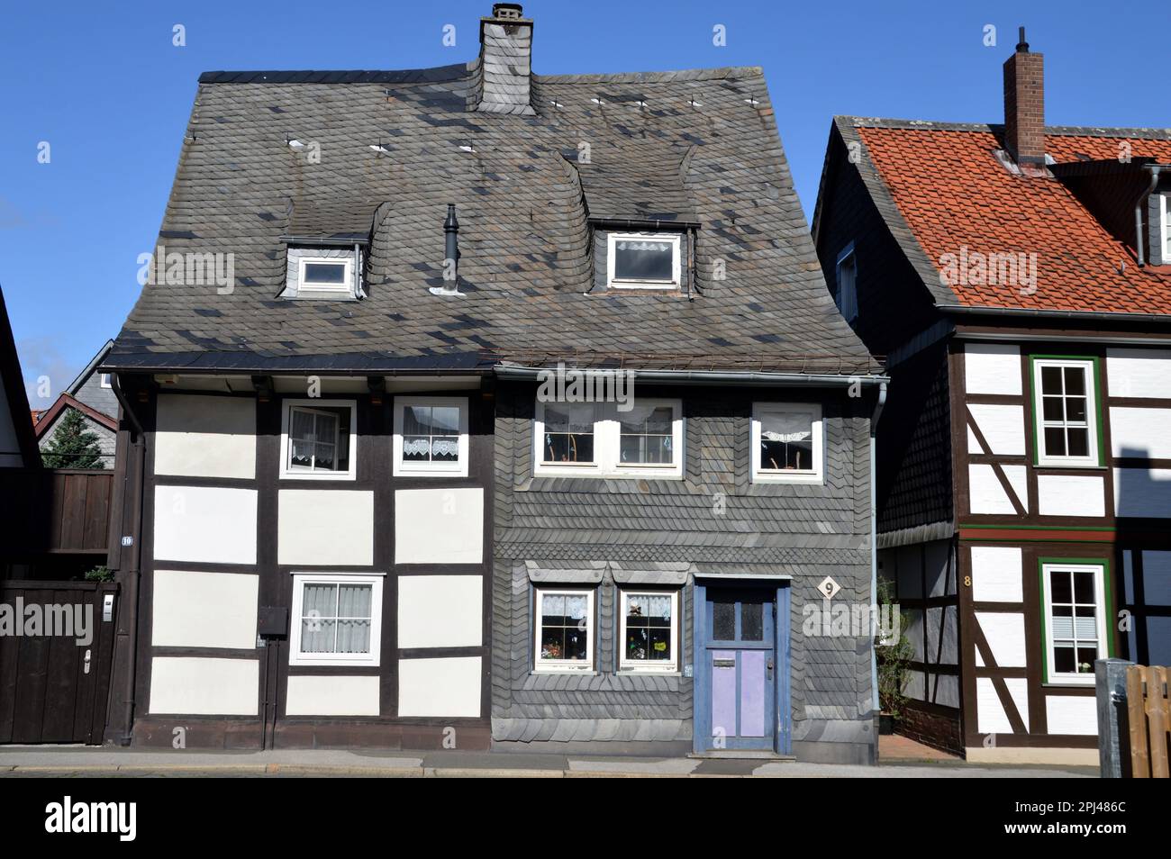 Germany, Lower Saxony, Goslar:  semi-detached timber-frame houses, one with ornate slate-cladding, a local tradition. Stock Photo