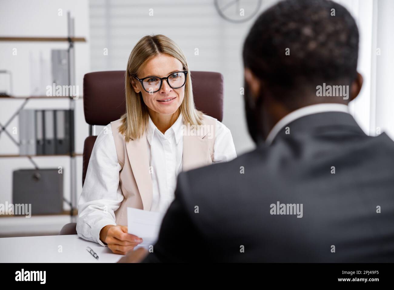 Hiring, interview. Middle-aged blond business woman conducting an ...