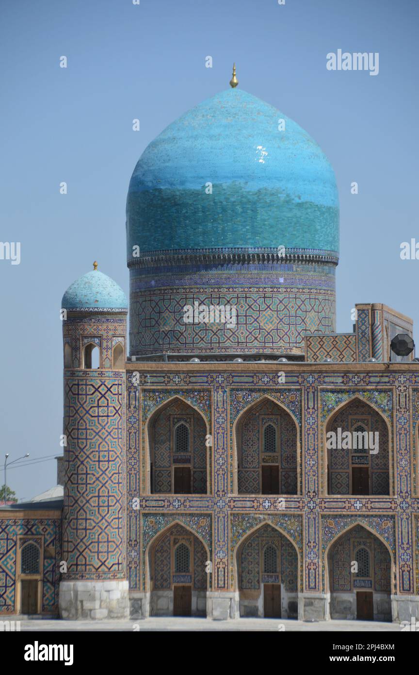 Uzbekistan, Samarkand, Registan:  turquoise single dome of Tilya-Kori madrasa, asymetrically placed, with part of the two-storey facade, richly decora Stock Photo