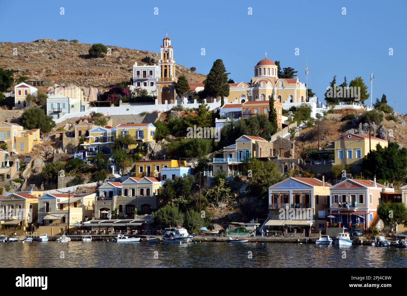 Greece, Island of Symi, Gialos:  Orthodox church and  belltower dominate the headland between the two bays. Stock Photo