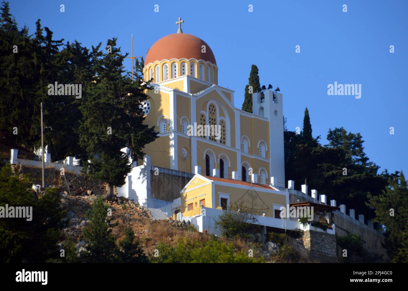 Greece, Island of Symi, Gialos:   a handsome, domed, Orthodox church commands the harbour from on high. Stock Photo