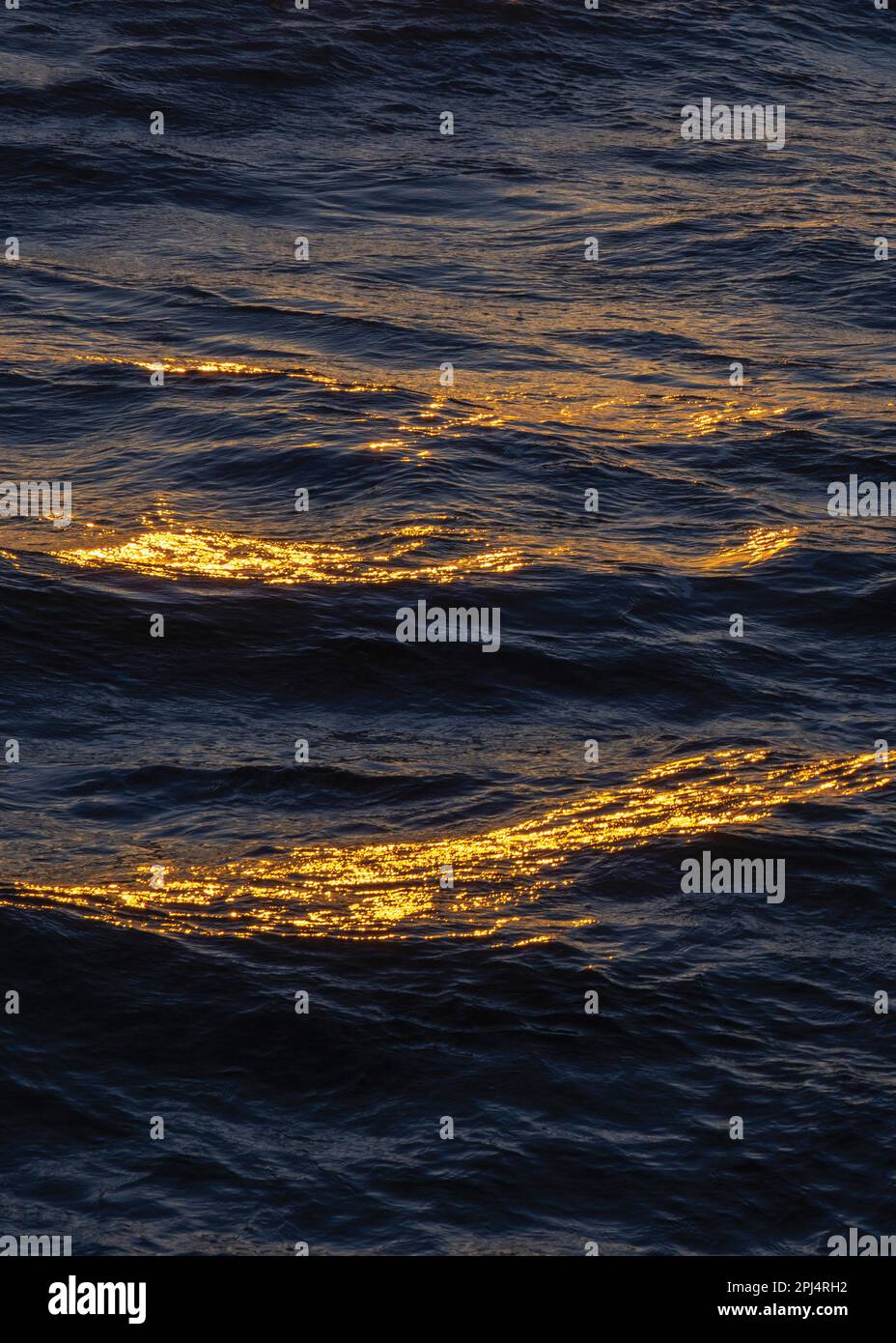Sunset reflection on waves in sea. Stock Photo
