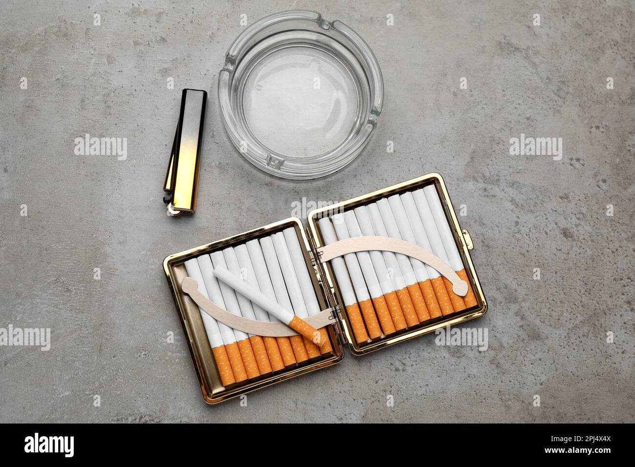 Open case with tobacco filter cigarettes, lighter and empty glass