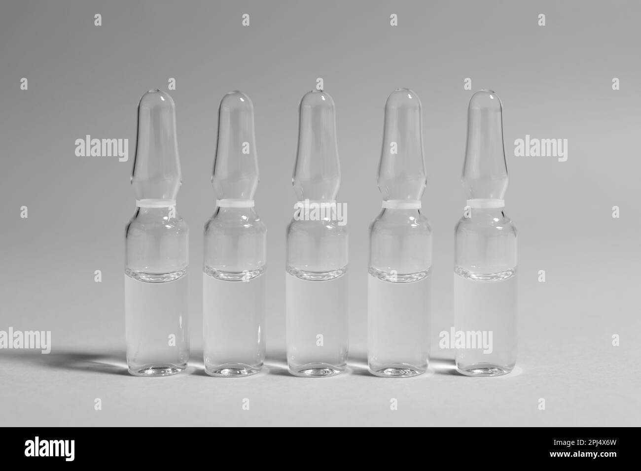 Pharmaceutical ampoules with medication on light grey background Stock