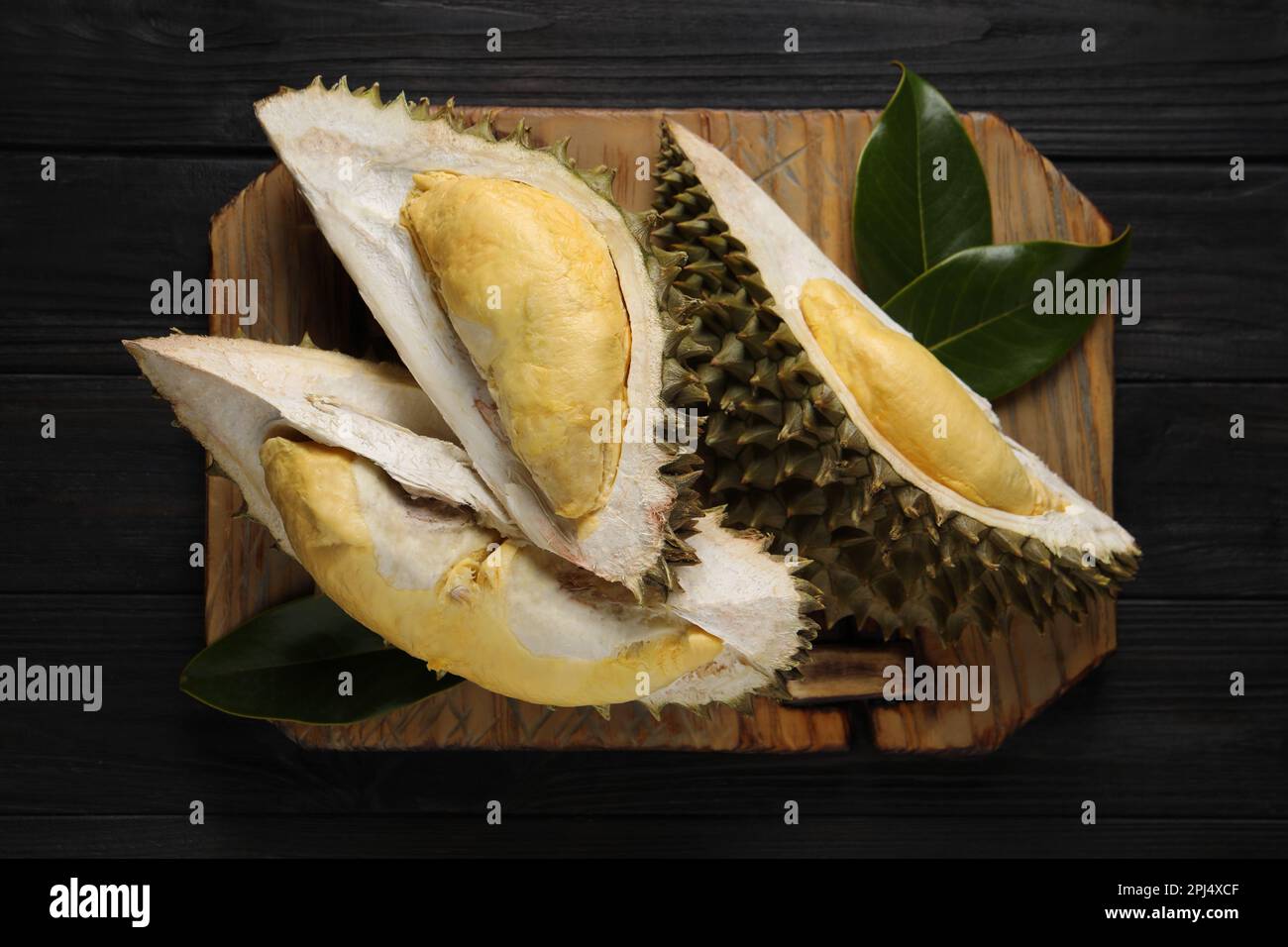 Pieces of fresh ripe durian on black wooden table, top view Stock Photo ...