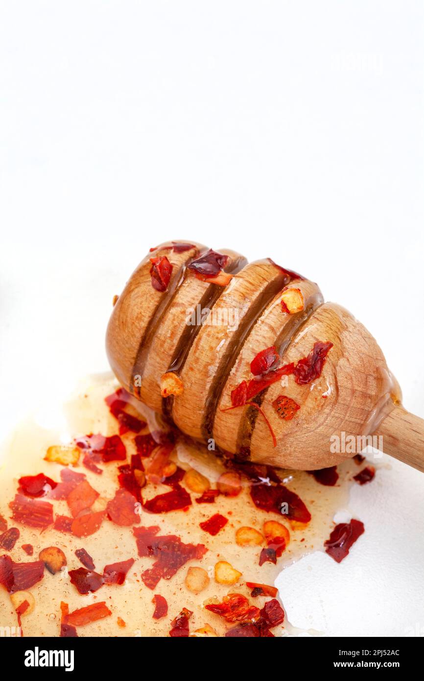 Hot honey or chili honey on white with loose chili flakes Stock Photo